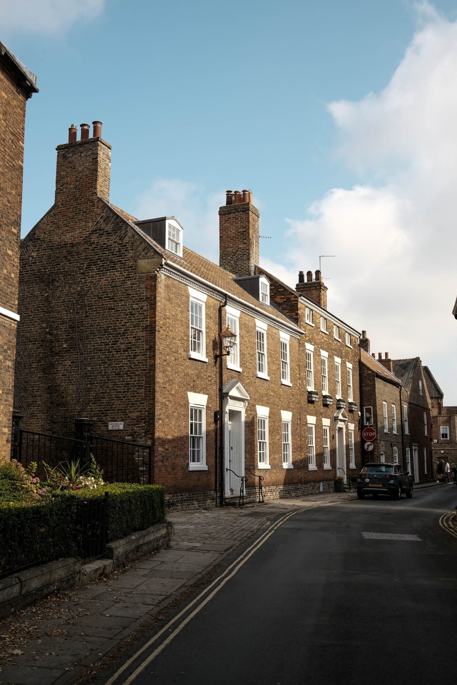 Charming street view of traditional British brick buildings under a clear sky.